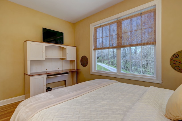 bedroom featuring baseboards and wood finished floors