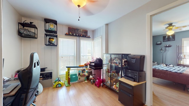 game room with ceiling fan, light wood finished floors, and an office area