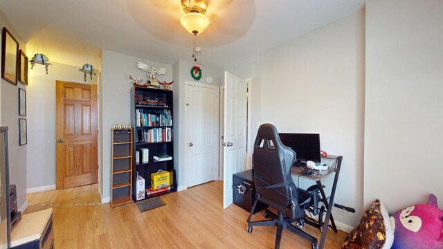office featuring light wood-type flooring, ceiling fan, and baseboards