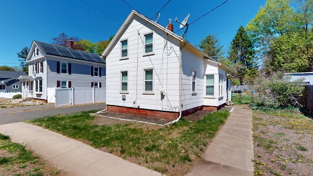 view of front of home featuring fence and a chimney