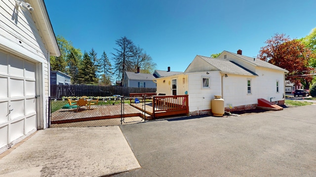 view of home's exterior with fence, a deck, and a patio