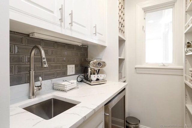 81 Silver Hill Rd, Ridgefield, CT 06877 - kitchen featuring white cabinets, backsplash, light stone counters, and a sink