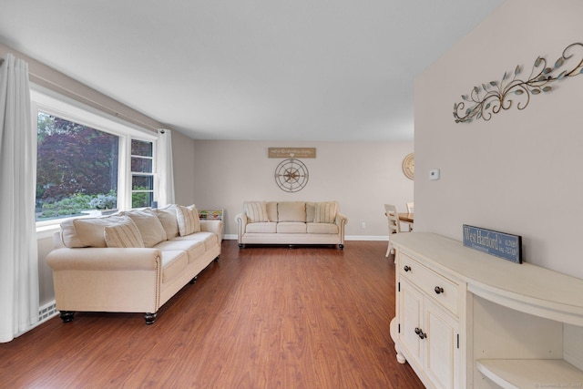 living room featuring dark wood-style flooring and baseboards