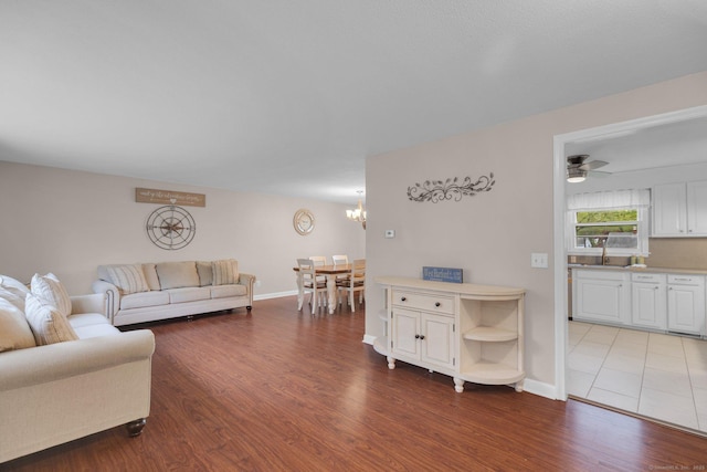 living room with wood finished floors, a chandelier, ceiling fan, and baseboards