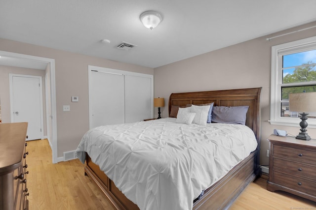 bedroom featuring light wood-style flooring, a closet, and baseboards