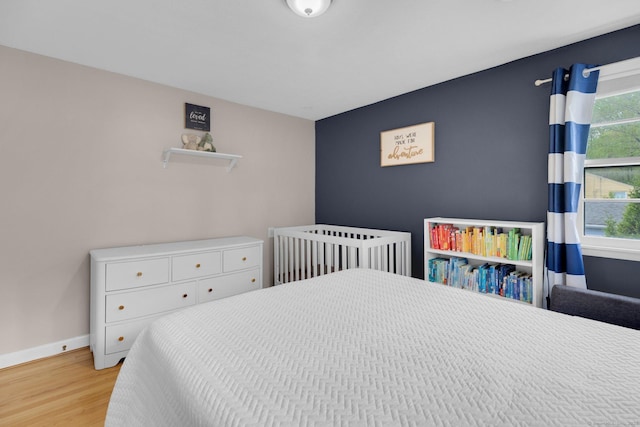 bedroom with light wood-type flooring and baseboards