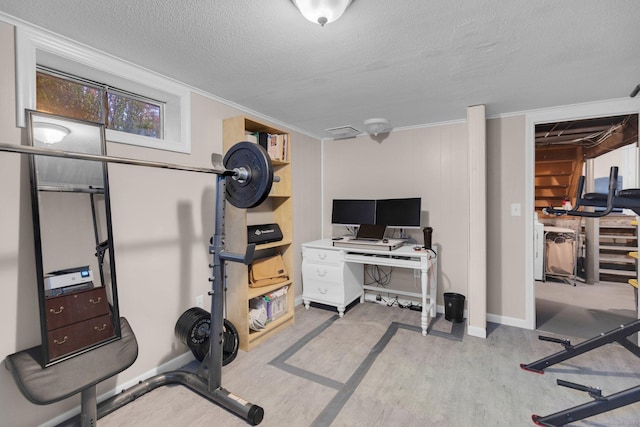workout area with wood finished floors, a textured ceiling, baseboards, and crown molding