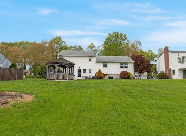 back of house with a gazebo and a lawn