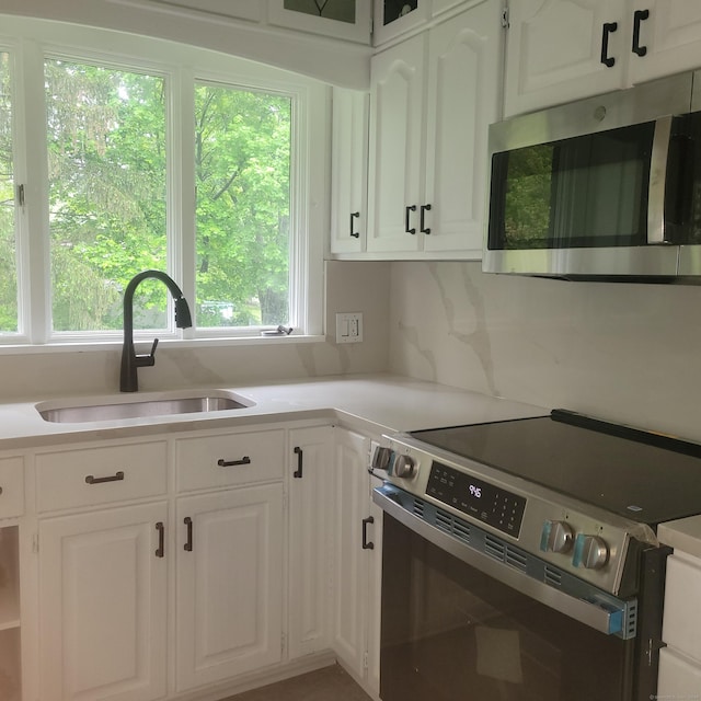 1848 Waterbury Rd, Cheshire, CT 06410 - kitchen featuring appliances with stainless steel finishes, a sink, white cabinetry, and light countertops