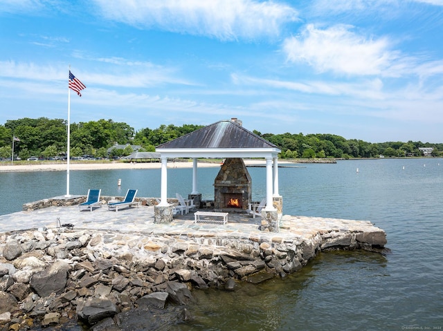 dock area featuring a gazebo, a water view, and a patio area
