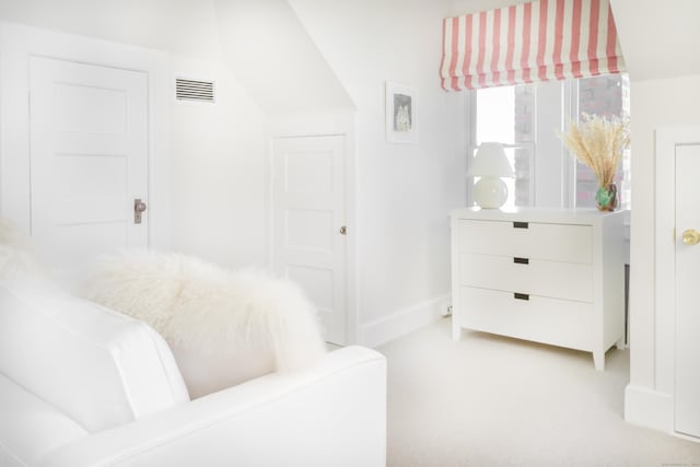 bedroom featuring baseboards, light carpet, and visible vents