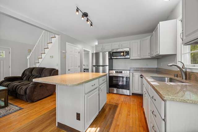 1343 Baldwin Hill Rd, Ledyard, CT 06335 - kitchen with a sink, appliances with stainless steel finishes, light wood finished floors, and a kitchen island