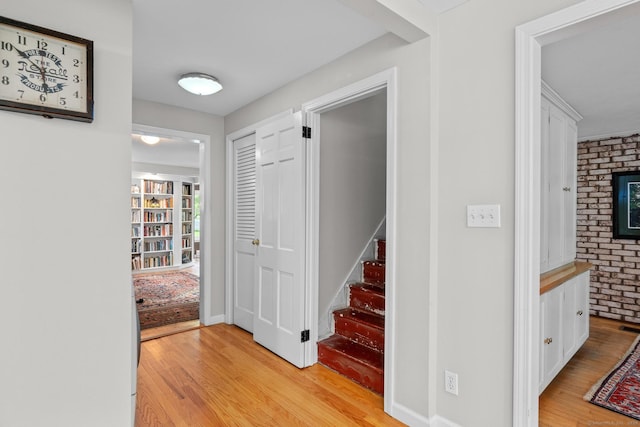 309 N Grand St, Suffield, CT 06093 - hallway with light wood finished floors, stairway, and brick wall