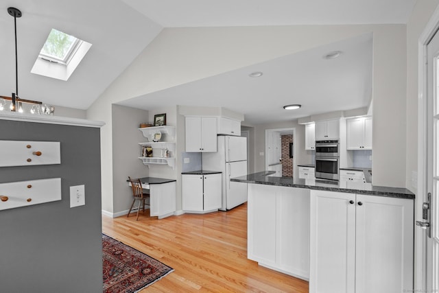 309 N Grand St, Suffield, CT 06093 - kitchen featuring freestanding refrigerator, double oven, a skylight, white cabinets, and vaulted ceiling
