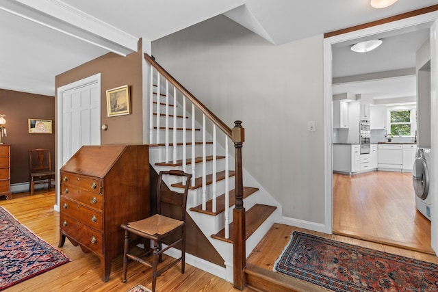 309 N Grand St, Suffield, CT 06093 - stairway featuring baseboard heating, washer / clothes dryer, wood-type flooring, and baseboards