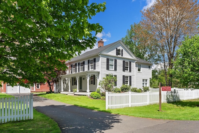 309 N Grand St, Suffield, CT 06093 - view of front of home featuring a chimney, driveway, and covered porch