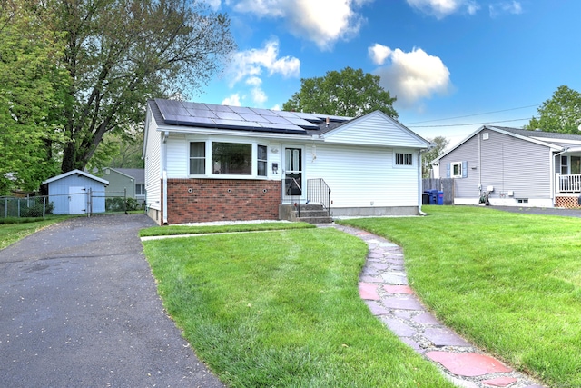 27 Aircraft Rd, West Haven, CT 06516 - view of front of property featuring roof mounted solar panels, brick siding, and asphalt driveway