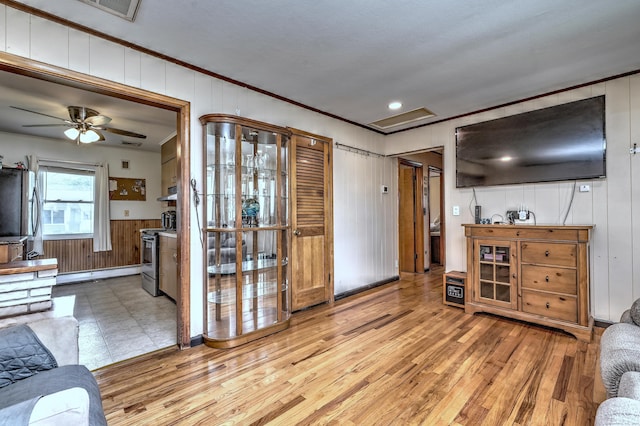 27 Aircraft Rd, West Haven, CT 06516 - living room with crown molding, wood walls, light wood finished floors, ceiling fan, and baseboard heating