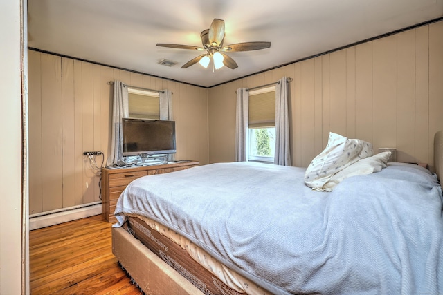 27 Aircraft Rd, West Haven, CT 06516 - bedroom featuring baseboard heating, wood finished floors, ceiling fan, and wood walls