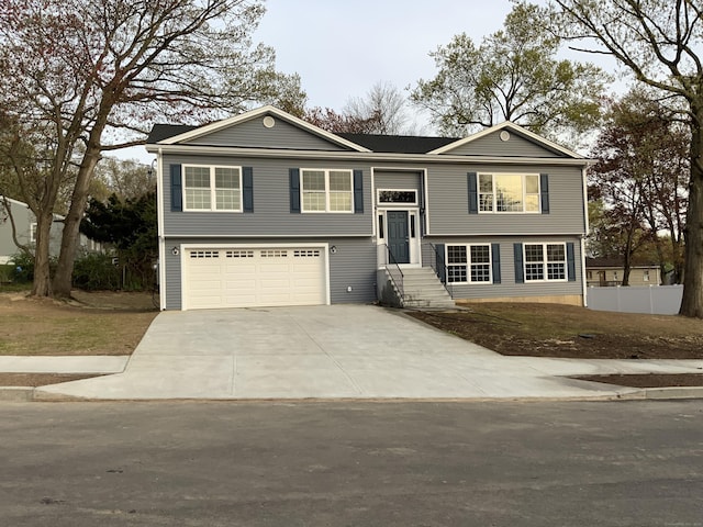 split foyer home featuring concrete driveway, an attached garage, and entry steps