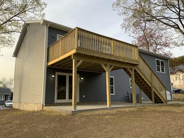back of property featuring a wooden deck, a patio area, and stairway
