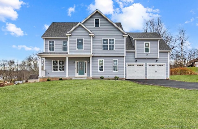 view of front facade featuring a garage, covered porch, driveway, and a front lawn