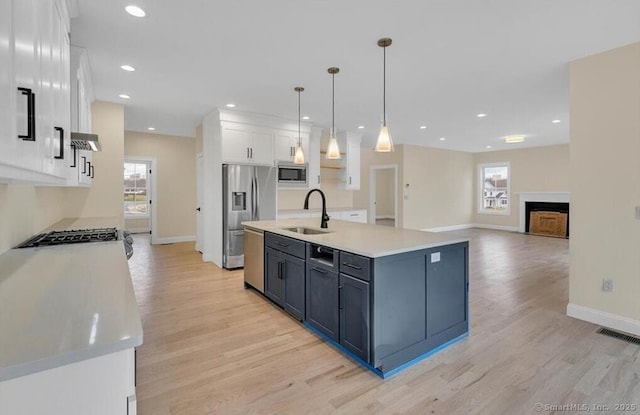 kitchen with a sink, white cabinets, a wealth of natural light, and stainless steel appliances