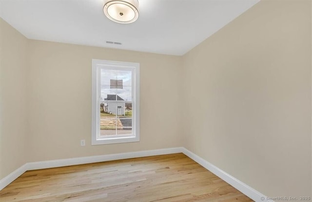 unfurnished room featuring light wood-style floors, baseboards, and visible vents