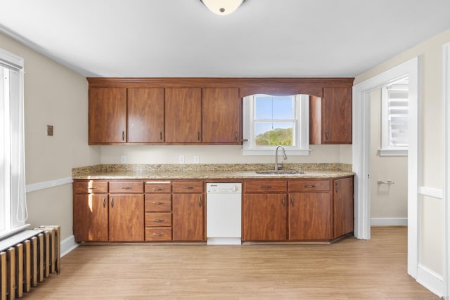 kitchen featuring radiator, baseboards, white dishwasher, a sink, and light wood finished floors