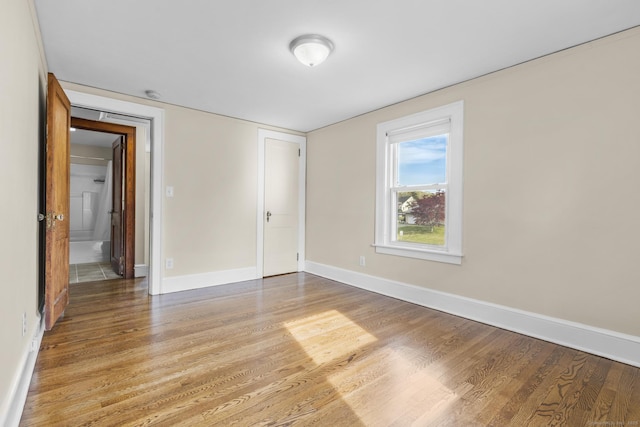 unfurnished bedroom with baseboards and light wood-type flooring