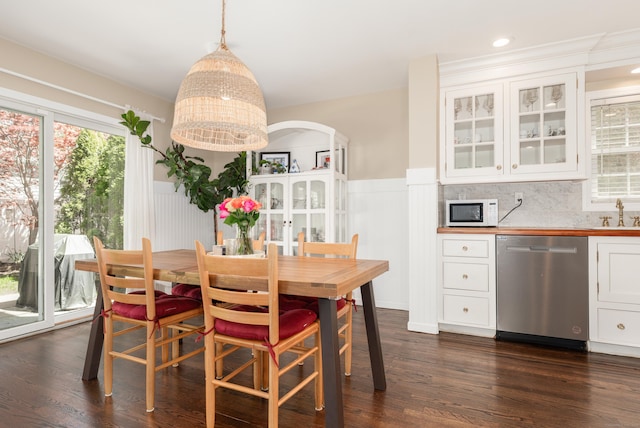 39 Wildemere Ave, Milford, CT 06460 - dining space with plenty of natural light, wainscoting, dark wood-style floors, and indoor bar