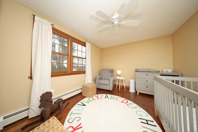 227 Hany Ln, Vernon, CT 06066 - bedroom with baseboard heating, dark wood-type flooring, a ceiling fan, and a nursery area