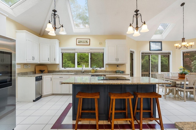 498 Eastbury Hill Rd, Glastonbury, CT 06033 - kitchen featuring a skylight, a chandelier, a sink, white cabinetry, and light tile patterned floors