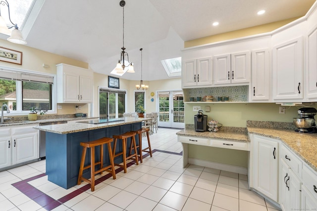 498 Eastbury Hill Rd, Glastonbury, CT 06033 - kitchen with a skylight, dishwasher, white cabinetry, black electric stovetop, and a kitchen island