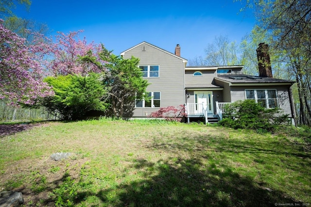 back of property featuring a lawn and a chimney