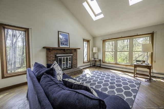 living room featuring a brick fireplace, a skylight, plenty of natural light, and wood finished floors