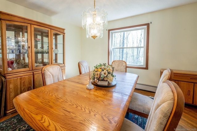 dining area with dark wood-style flooring, an inviting chandelier, and a baseboard radiator