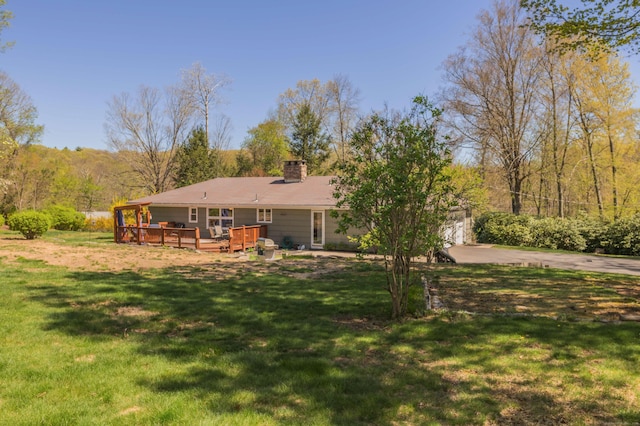 97 Doolittle Dr, Bethany, CT 06524 - back of property featuring a lawn, a wooden deck, a chimney, and concrete driveway