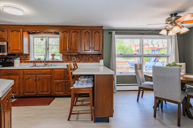 97 Doolittle Dr, Bethany, CT 06524 - kitchen featuring light wood finished floors, light countertops, stainless steel microwave, backsplash, and black stove