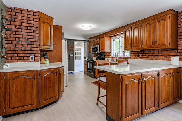 97 Doolittle Dr, Bethany, CT 06524 - kitchen featuring a peninsula, black / electric stove, stainless steel microwave, and light wood-type flooring