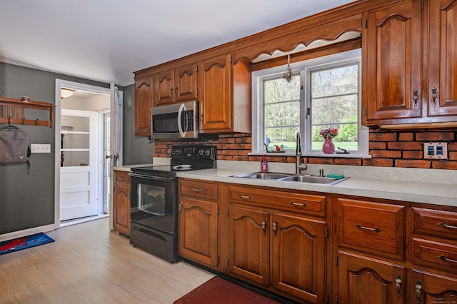 97 Doolittle Dr, Bethany, CT 06524 - kitchen with light countertops, stainless steel microwave, black range with electric stovetop, a sink, and backsplash