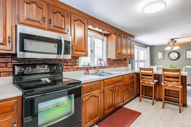 97 Doolittle Dr, Bethany, CT 06524 - kitchen with light countertops, stainless steel microwave, a sink, and black range with electric stovetop