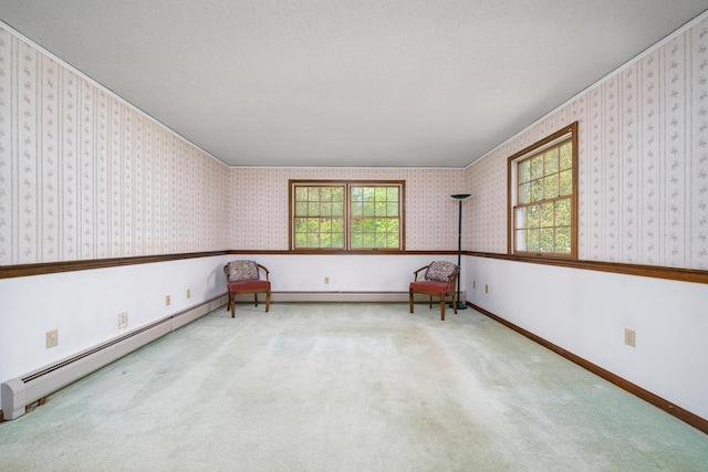 spare room with carpet, baseboards, and a baseboard heating unit