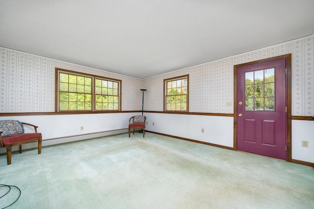 unfurnished room featuring carpet flooring, wallpapered walls, baseboards, and a baseboard heating unit