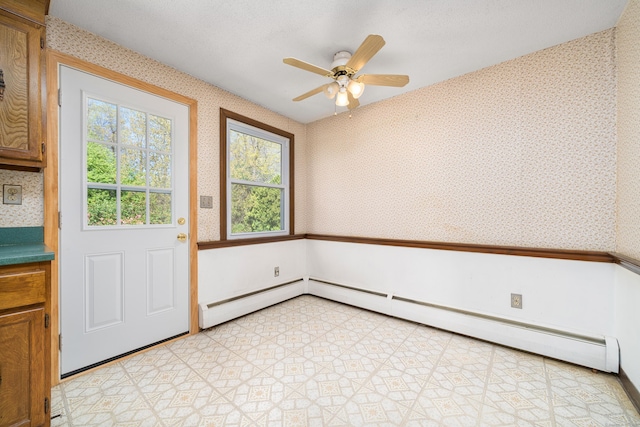 doorway featuring wallpapered walls, a ceiling fan, and a baseboard heating unit