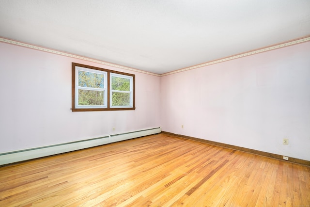 unfurnished room featuring hardwood / wood-style floors, baseboards, a baseboard heating unit, and ornamental molding
