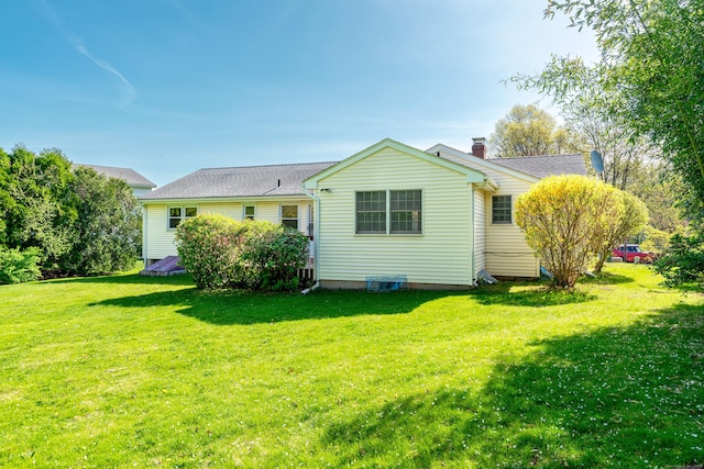 rear view of property with a lawn and a chimney