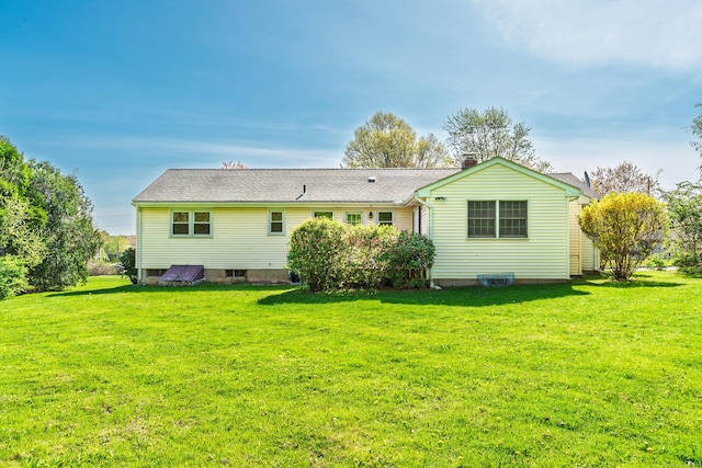 back of property featuring a yard and a chimney