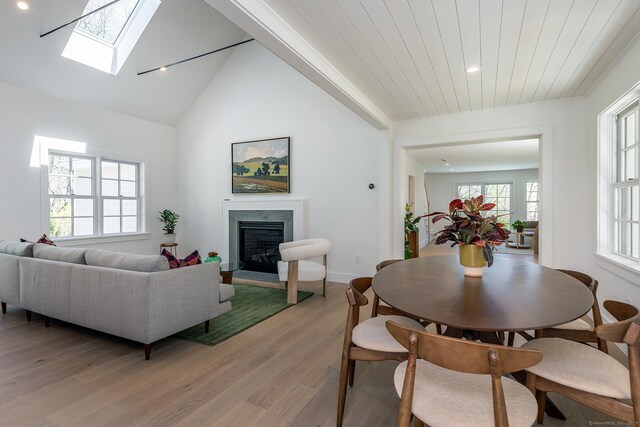 24 Tompkins Hill Rd, Washington, CT 06793 - dining space featuring a fireplace, light wood-style floors, a skylight, recessed lighting, and baseboards