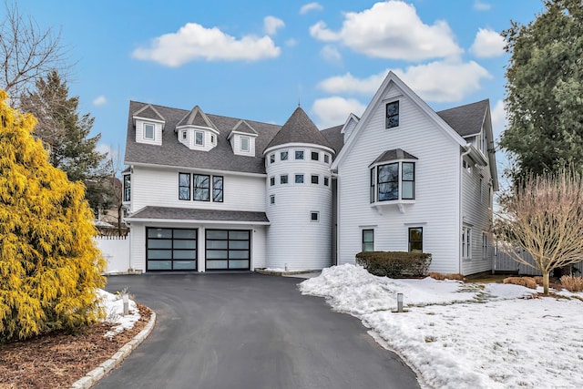 view of front facade featuring roof with shingles, an attached garage, and aphalt driveway